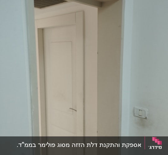 דלת לבנה מותקנת במסגרת קיר